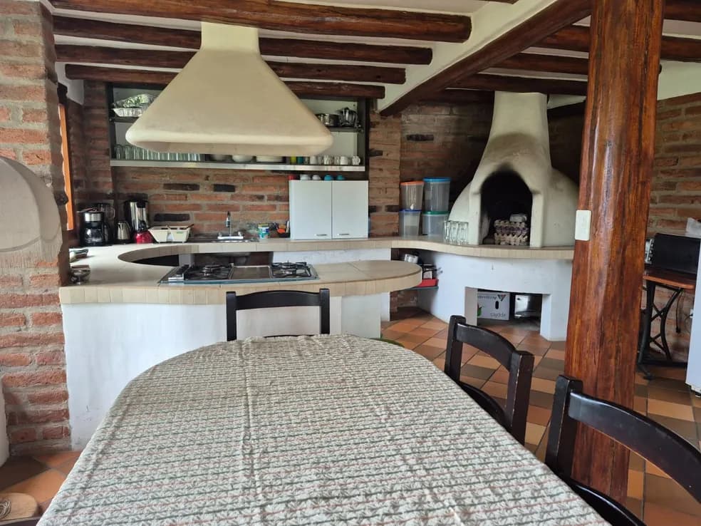 Bunk bed beneath a round brick portal window in a participant cabin at Teos